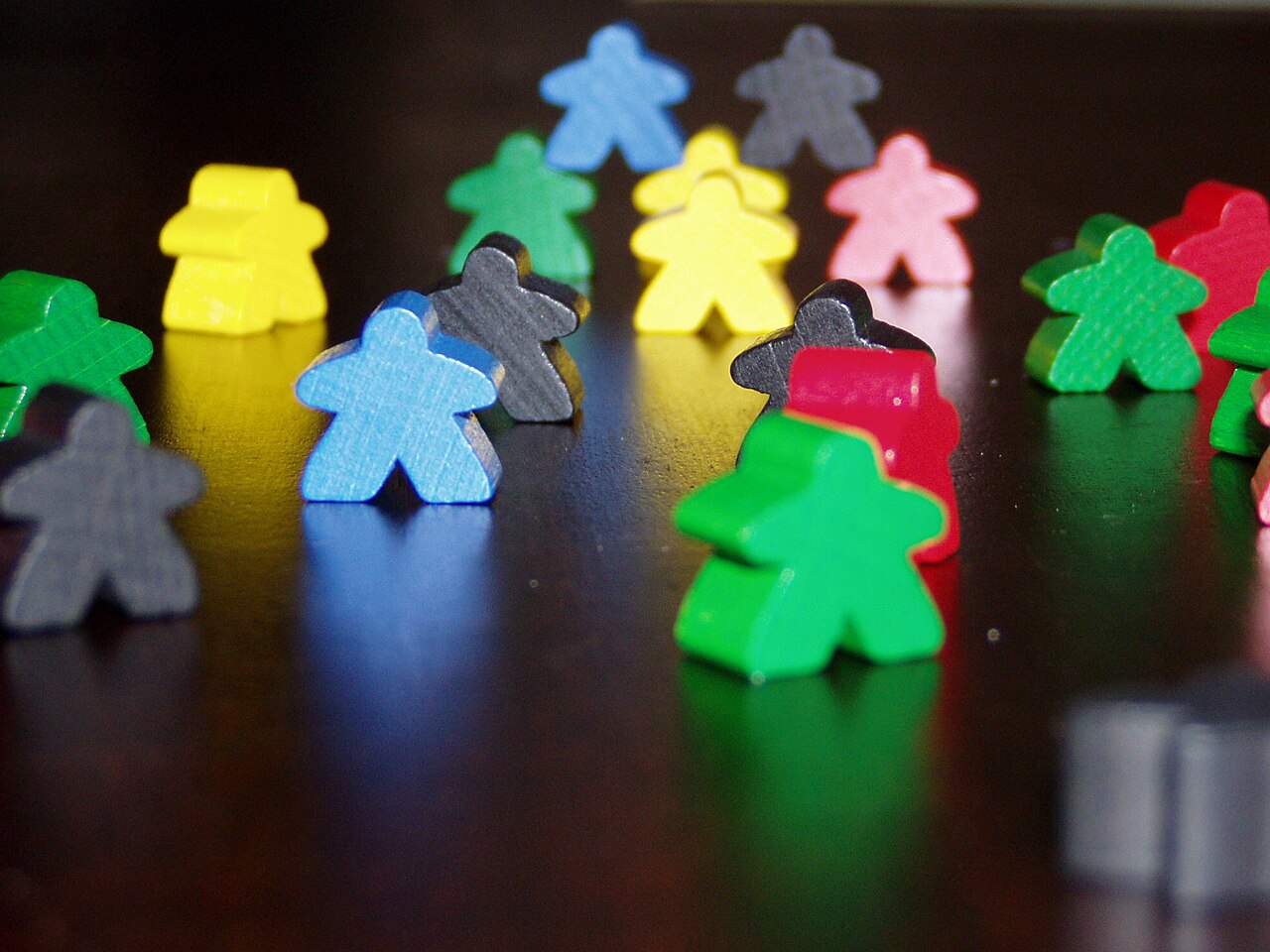 Bunte Carcassonne-Spielfiguren (Meeples) in Nahaufnahme